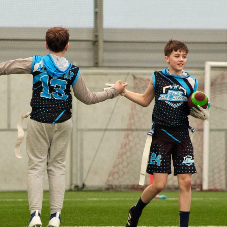 Fife All Stars flag football players high-fiving each other. Fife All Stars flag football players high-fiving each other.