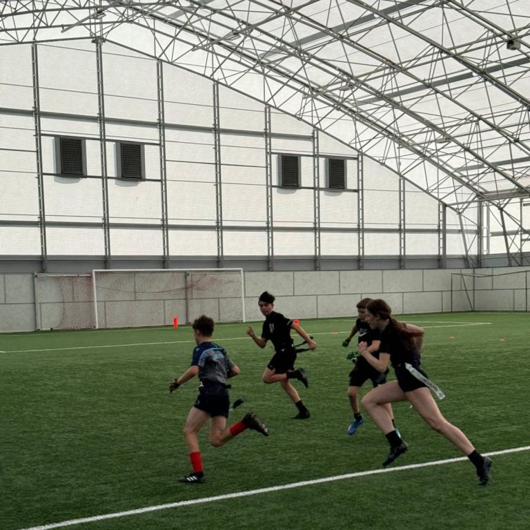 Fife All Stars flag football players chasing each other on indoor pitch. Fife All Stars flag football players chasing each other on indoor pitch.